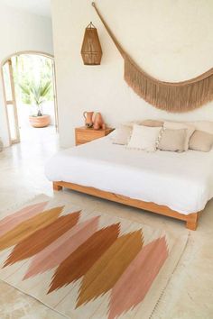 a bedroom with a large bed and rugs on the floor