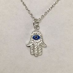 "925 STERLING SILVER HAMSA AND EVIL EYE PENDANT . HAMSA AND EVIL EYE FOR PROTECTION AND GOOD LUCK. 18\" TO 20\" ADJUSTABLE CHAIN. PENDANT SIZE 15 mm X 10 mm CADENA DE 925 PLATA ESTERLINA MANO DE FATIMA Y OJO DE LA BUENA SUERTE. LA MANO DE FATIMA Y OJO PARA BUENA SUERTE Y PROTECCION. 18\" A 20\" CADENA AJUSTABLE. TAMAÑO DEL DIJE : 15 mm X 10 mm" White Sterling Silver Spiritual Charm Necklaces, Spiritual White Sterling Silver Charm Necklace, Symbolic Sterling Silver Dangle Charm Necklaces, Spiritual Sterling Silver Charm Necklaces In Silver, Spiritual Sterling Silver Charm Necklace In Silver, White Sterling Silver Symbolic Necklace, Symbolic Sterling Silver Charm Necklace With Adjustable Chain, Spiritual Sterling Silver Charm Necklace With Adjustable Chain, Symbolic Sterling Silver Good Luck Charm Necklace