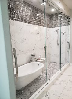 a bathroom with marble walls and flooring next to a bathtub in the corner