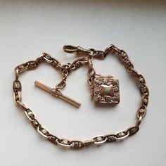 A very nice ornate and heavy Edwardian watch chain with very detailed locket.  Each chain link has a very detailed rosette in the center.  The locket box is decorated with paisleys around the edges.  There is wear on the front and back of the locket but it is still very beautiful.  The chain is in excellent condition with very slight wear.  This is an incredibly beautiful chain; a great addition to any collection.  The chain measures 13" in length and the locket measures 1" diagonally.  The swiv Luxury Vintage Watch Accessories With Stainless Steel Clasp, Elegant Medallion Pocket Watch For Wedding, Rose Gold Locket Necklace For Formal Occasions, Elegant Wedding Pocket Watch, Timeless Antique Gold Medallion Jewelry, Elegant Gold Pocket Watch With Locket, Antique Engraved Link Necklace, Antique Engraved Link Necklaces, Antique Oval Link Chain Jewelry