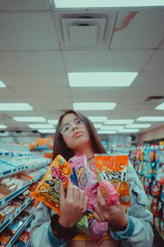 a woman is holding some snacks in her hands