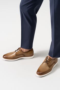 The Leone showcases Magnanni's take on a sophisticated dress hybrid. This dapper blucher features a traditional lace up design in supple calfskin leathers. The sleek dress silhouette is complemented with a comfortable and cushioned white rubber sole, making it the ideal selection for an on-the-go lifestyle. Modern Business Casual Lace-up Shoes With Round Toe, Fitted Timeless Leather Lace-up Shoes, Timeless Semi-formal Lace-up Calf Leather Shoes, Fitted Lace-up Shoes For Semi-formal Occasions, Leather Wingtip Lace-up Shoes For Business Casual, Modern Business Casual Lace-up Shoes With Leather Sole, Timeless Leather Lace-up Shoes With Brogue Detailing, Brown Leather Shoes For Spring Semi-formal, Leather Lace-up Shoes With Textured Sole For Business Casual