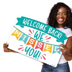 a woman holding a sign that says welcome back we missed you