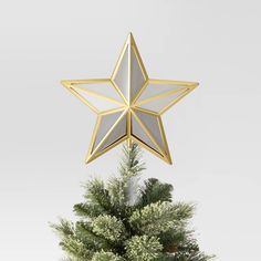 a gold and white star decoration on top of a christmas tree