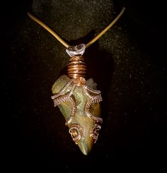 a necklace with an animal's head on it and some wire wrapped around it