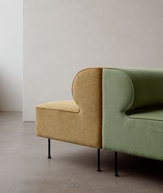 a green and yellow couch sitting next to each other on top of a cement floor