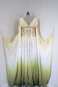 a white and yellow dress hanging on a wall