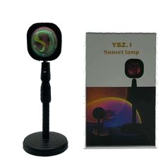 a black and green light is in front of a white box with the words vz 1 sunset lamp on it