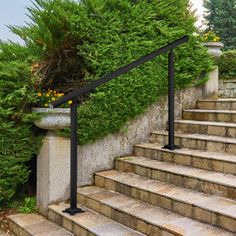 the stairs are made of stone and have black railings