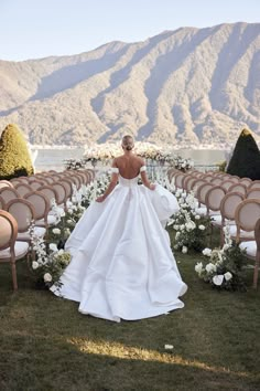 a woman in a white wedding dress standing next to rows of chairs