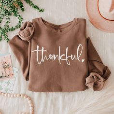 Elevate your casual style with this unisex lightweight Thankful crewneck sweatshirt. Crafted from 100% ring-spun cotton, it offers a soft and smooth feel, perfect for layering or wearing on its own. The relaxed fit ensures comfort, making it an ideal choice for lounging at home, running errands, or enjoying a casual day out with friends. Perfect for all genders, this women's thanksgiving sweatshirt is a great gift for birthdays, holidays, and seasonal celebrations. Its versatility makes it suita Thanksgiving Sweatshirt Ideas, Thanksgiving Shirts For Women, Fall Bonfire, Fall Crewneck Sweatshirt, Thankful Sweatshirt, Thanksgiving Sweater, Thanksgiving Sweatshirt, Holiday Sweatshirt, Fall Gifts