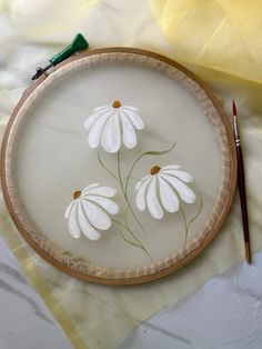 a embroidery kit with three white flowers on it