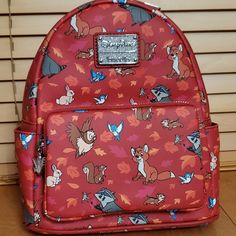 a red backpack with cartoon characters all over it