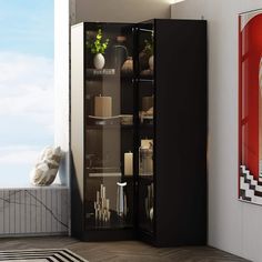 a tall black cabinet sitting on top of a hard wood floor next to a window