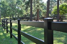 a wooden fence in the middle of a grassy field