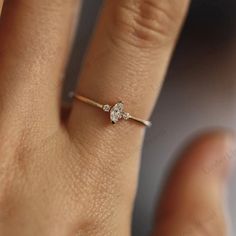 a woman's hand with a diamond ring on her finger, showing the side view