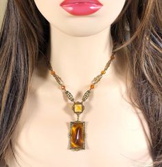 Beautiful Czechoslovakian style 1930-1940 amber colorded glass pendant on a detailed gold tone link chain with amber colorded crystal beads. Dress up or dress down this stunning piece; unmarked. Antique Amber Pendant Necklaces, Antique Amber Pendant Necklace, Antique Gold Beaded Vintage Necklace, Vintage Beaded Antique Gold Necklace, Vintage Amber Beaded Necklace, Vintage Baltic Amber Jewelry For Formal Occasions, Vintage Bronze Beaded Chain Jewelry, Vintage Beaded Pendant Jewelry, Vintage Beaded Chain Pendant Jewelry