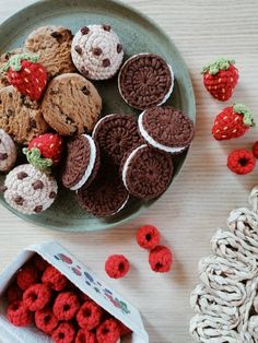 there are many crocheted cookies and muffins on the plate next to each other