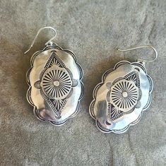 A large pair of shiny solid sterling silver concho  earrings, handmade, stamped and then slightly domed by me here in beea-utiful Tucson, Arizona. They're cut from hefty 20 gauge sterling sheet and weigh approximately 13.5 grams for the pair. Conchos measure 1 1/2" in length by 1 1/4" wide. With the earwire, they're approximately 2" long - and will definitely get you noticed! Nice and deeply stamped for surface texture using vintage navajo-style stamps, these earrings will last a lifetime - a tr Cheap Silver Concho Earrings, Southwestern Silver Teardrop Earrings, Traditional Concho Earrings As Gift, Traditional Concho Earrings For Gift, Unique Sterling Silver Concho Jewelry, Traditional Silver Concho Jewelry, Silver Concho Drop Earrings, Artisan Stamped 925 Earrings, Southwestern Silver Concho Earrings