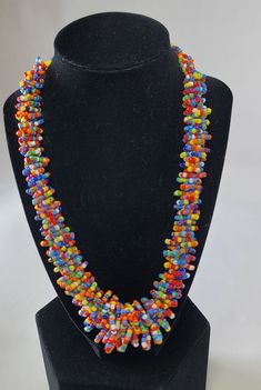 Stand out in style with this beautiful handmade loop bead style necklace. Hover over the photo to see the detail of how the beads are made into a loop design. Thoughtfully designed for style and stand out fashion. Approximately 18" end to end. Unique Long Beaded Necklace With Faceted Beads, Adjustable Rainbow Polished Beads Necklace, Adjustable Rainbow Necklaces With Polished Beads, Rainbow Faceted Round Bead Necklaces, Spiral Multicolor Necklace Gift, Multicolor Spiral Necklace Gift, Colorful Czech Glass Beaded Necklaces, Beaded Necklace With Oval Beads For Party, Rainbow Faceted Beads Necklace