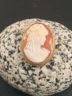 "This is a beautiful vintage 9ct yellow gold cameo brooch. The shell is a dark peach colour with a side view image of a lady in ivory all of which is set in a rope edged 9ct gold casing. There is a small link at the back of the brooch suitable to attach a safety chain if necessary. The brooch/pendant is supplied with a FREE GIFT BOX and I can also gift wrap the brooch if it I sent given as a gift. Dimensions Weight : 7.8g Width : 1\" Length : 1.25\"" Classic Cameo Collectible Brooches, Heirloom Cameo Brooch Gift, Heirloom Cameo Brooches As Gift, Heirloom Cameo Brooches For Gifts, Vintage Cameo Brooch In Yellow Gold, Victorian Cameo Brooches In Yellow Gold, Antique Oval Cameo Brooch, Victorian Cameo Brooch In Yellow Gold, Antique Cameo Oval Cabochon Jewelry