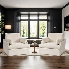 a living room with two chairs and a coffee table in front of a large window