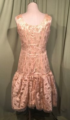 "This is a vintage formal dress from the early 60s. No labels or tags. The bust measures 36\", waist 30\", see measurements below, but it would look best on a slightly smaller bust & waist. Made of gold lace over a satin underlayer. It is a drop waist dress with bubble hemline. It is sleevless with a wide neckline. The bubble skirt is gathered & lined with pellon for stiffness & fullness. The skirt is trimmed to one side with a swoop of fabric & a gold metallic, fabric rose. Zips Fitted A-line Vintage Dress With Ruffles, Elegant Fitted Vintage Prom Dress, Vintage Evening Dress With Lined Bodice, Vintage Evening Dresses With Lined Bodice, Retro Formal Dress With Fitted Bodice, Vintage Knee-length Prom Dresses, 1950s Fitted Vintage Dress For Formal Occasions, 1950s Vintage Fitted Dress For Formal Occasions, Fitted 1950s Style Dresses For Vintage Events