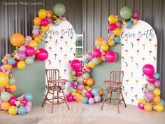 balloons and chairs in front of a backdrop for a birthday party