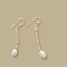 Elevate your bridal ensemble with our exquisite freshwater pearl drop earrings. Crafted to perfection, these stunning earrings feature lustrous pearls delicately suspended from 24K gold-plated dangles, adding a touch of timeless elegance to your wedding day look. Perfect for brides seeking refined sophistication, these bridal pearl earrings exude understated glamour and effortless charm. Handcrafted with care, these earrings are not just an accessory, but a symbol of everlasting love and beauty. Add a touch of luxury to your special day with these heirloom-worthy treasures. Delicate Dangle Bridal Earrings With Pearl Pendant, Delicate Bridal Dangle Earrings With Pearl Pendant, Graceful Dangle Bridal Earrings For Gift, Graceful Pearl Drop Dangle Bridal Earrings, Graceful Bridal Dangle Earrings With Pearl Drop, Delicate Dangle Earrings With Pearl Pendant, Dainty Drop Earrings With Pearl Chain, Yellow Gold Pearl Drop Bridal Earrings, Dainty Bridal Pearl Drop Earrings