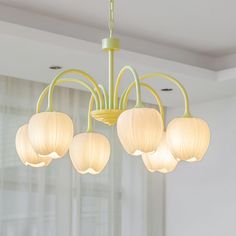 a chandelier hanging from the ceiling in a room with white walls and curtains