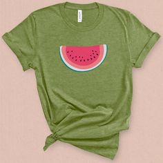 This minimal watermelon graphic t-shirt with its subtle retro feel comes straight from the pages of yesteryear. This wedge of watermelon graphic tee is supper sweet without being sticky. Its a perfect companion for your a pair of jean shorts and a hot summer day. DETAILS This Beautiful graphic t-shirt is made of 49% to 100% combed and ring-spun cotton and is very soft and comfortable to wear. Check the size card for specific fabrications per color. We use DTG technology and eco friendly inks all Cute Graphic Design T-shirt For Summer, Summer Green Tops With Graphic Design, Green Graphic Design Summer Top, Green Graphic T-shirt For Summer, Cute Graphic Design Tops For Summer, Green Graphic Design T-shirt For Summer, Green Summer Shirt With Funny Print, Fun Summer Tops With Graphic Design, Green Graphic Tee For Summer