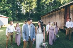 a group of people standing next to each other in front of a wooden structure and trees