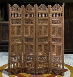 an intricately carved wooden room divider in the middle of a circular floor area