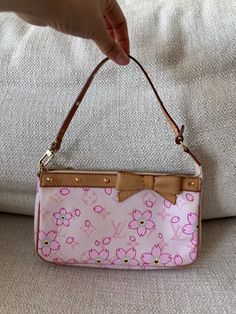 This is a gorgeous vintage 2003 Louis Vuitton X Takashi Murakami Limited Edition pink monogram with cherry blossoms pochette. Featuring vachetta leather trim with brass spike details on handle and trim, a vachetta leather bow detail and brass zipper closure with beige suede interior. I’m the original owner of this bag and I purchased it from a Louis Vuitton boutique in Paris.  Serial Number: AR0043 Year: 2003 Measurements: Length: 8.5”, Depth: 1.5”, Height: 5”, Handle Drop: 5.5” Material: Canvas & Leather Color: Pink Hardware: Brass Item Condition: Pre-Owned - Excellent Comes with original dust bag and original box Louis Vuitton Cherry Blossom Bag, Libra Style, Louis Vuitton Takashi Murakami, Fem Outfits, Louis Vuitton Murakami, Pink Cherry Blossom, Pink Monogram, Takashi Murakami, Pink Cherry