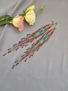 These very long and bright earrings are made of the smallest Toho seed beads, drops, Czech preciosa 3cut beads, Miyuki bugles, gold plated ear wires. So they are light, flying, ringing and dancing with every movement of the head. Thanks to such a variety of materials and textures used, the earrings are shimmering and interesting. Red and turquoise colors are complemented by bronze and black and white. Therefore, the earrings resemble the feathers of some wild, piercing tropical bird. Dangle Earrings Boho, Native American Beaded Earrings, Native American Beading, Handmade Boho, Turquoise Color, Fringe Earrings, Seed Bead Earrings, Bead Weaving, Boho Earrings