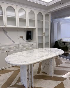 a marble dining table in the middle of a room with built - in bookcases