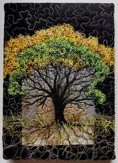 a tree with yellow and green leaves is shown on a black square tile wall hanging