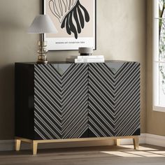 a black and white cabinet in a living room with a lamp on the sideboard