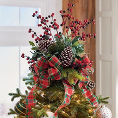 a decorated christmas tree with pine cones and berries