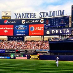 a baseball player standing on top of a field next to a stadium filled with people