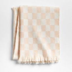 a beige and white checkered blanket with fringes