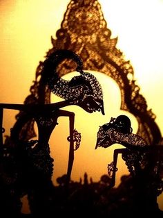 an intricately designed sculpture is shown in front of a yellow background with the sun behind it