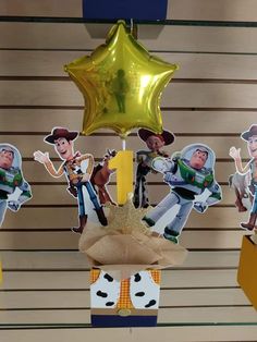 some toy story characters are hanging from the ceiling with gold foil stars on top of them