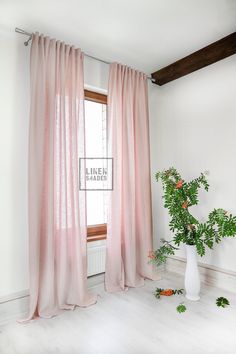 a white vase sitting next to a window with pink curtains