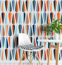 a chair and table in front of a colorful wallpaper