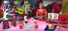 two women are sitting at a table with valentine's day decorations and gifts on it