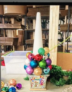 a vase filled with christmas ornaments on top of a table next to boxes and other items