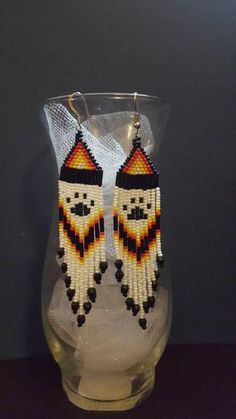 a pair of beaded native american style earrings in black, yellow and white colors