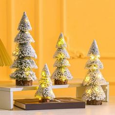 small christmas trees are lit up on a table