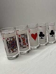 a row of shot glasses with playing cards on them